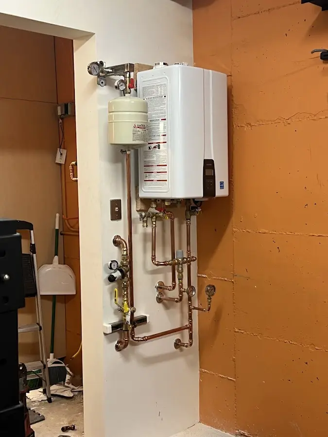 Plumbing technician inspecting water heater connections in Arlington